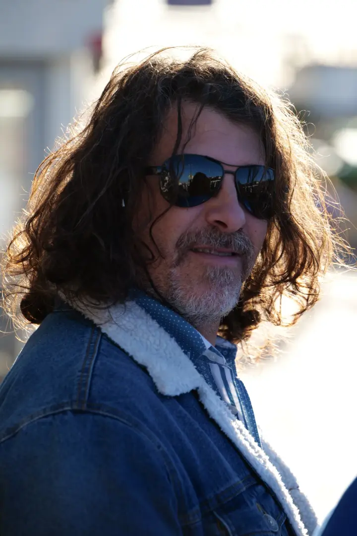Portrait d'un homme en veste en jean et lunettes de soleil