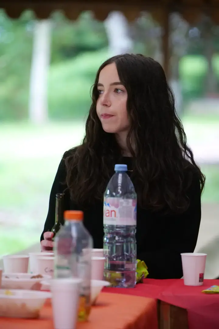 Portrait d'une jeune femme attablée en extérieur