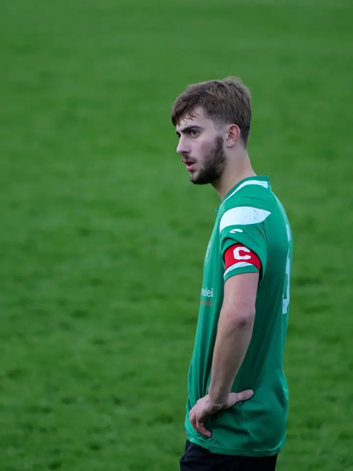 Footballeur, brassard de capitaine au bras, pendant un match